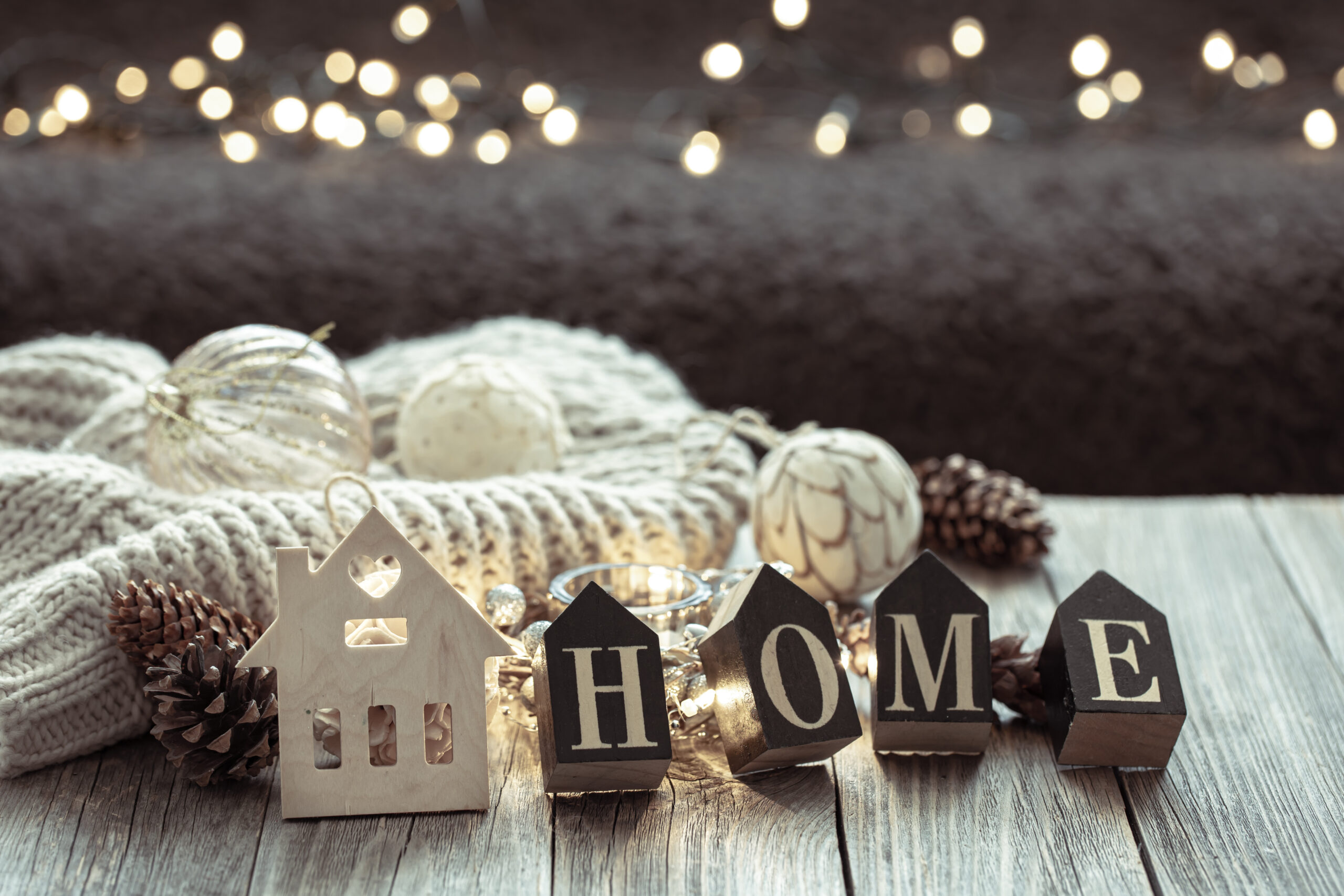 Cozy winter composition with the decorative word home on a blurred background.